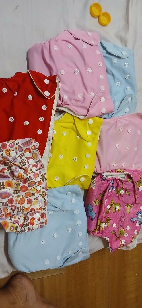Reusable Cloth Diapers - Various Colors and Prints (Category: Diapers & Baby Wipes) located in Caloocan City. Submitted by nathangrac08592 (Listing ID 1443313367, Image 2). Description: - Bundle of cloth diapers - Includes solid colors (pink, blue, yellow) and fun prints - Adjustable snaps for a customizable fit - Eco-conscious choice for parents - Comes with a red diaper cover.