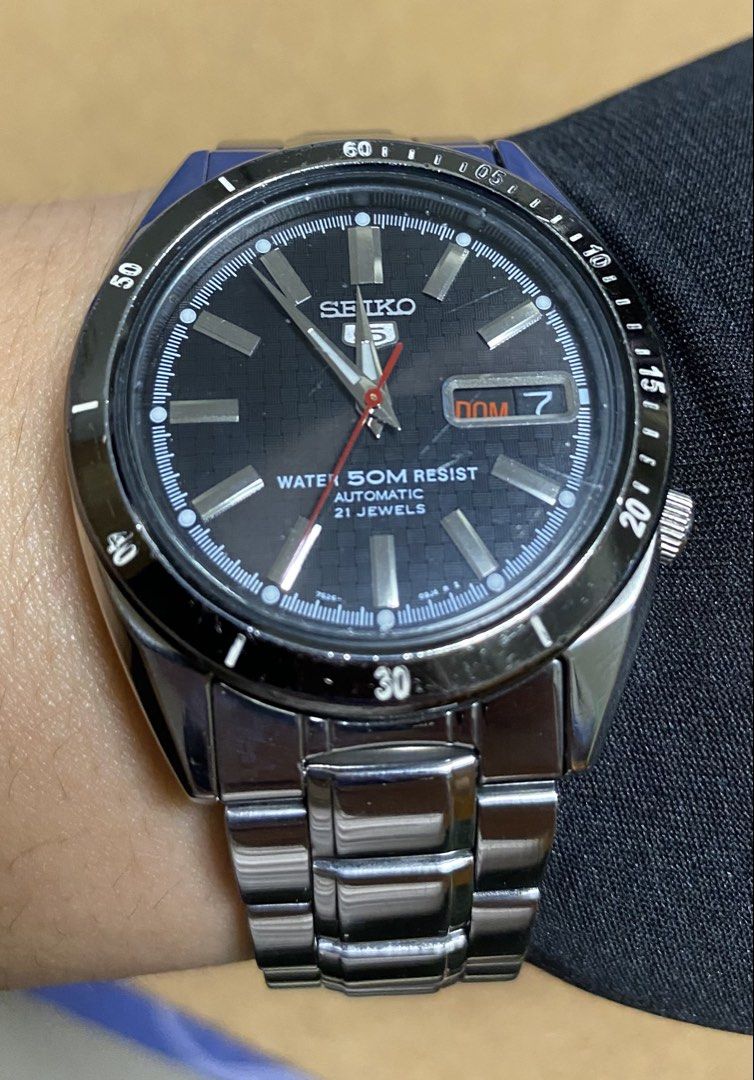 Seiko 5 Automatic Water 50M Resist Watch (Category: Men's Watches) located in Manila. Submitted by arjmalli02074 (Listing ID 1443299025, Image 1). Description: - Seiko 5 Automatic Watch -7s26 - 21 Jewels Automatic Movement - Water Resistant (50 meters) - Black Textured Dial (carbon fiber) with Day & Date Display - Stainless Steel Bracelet.