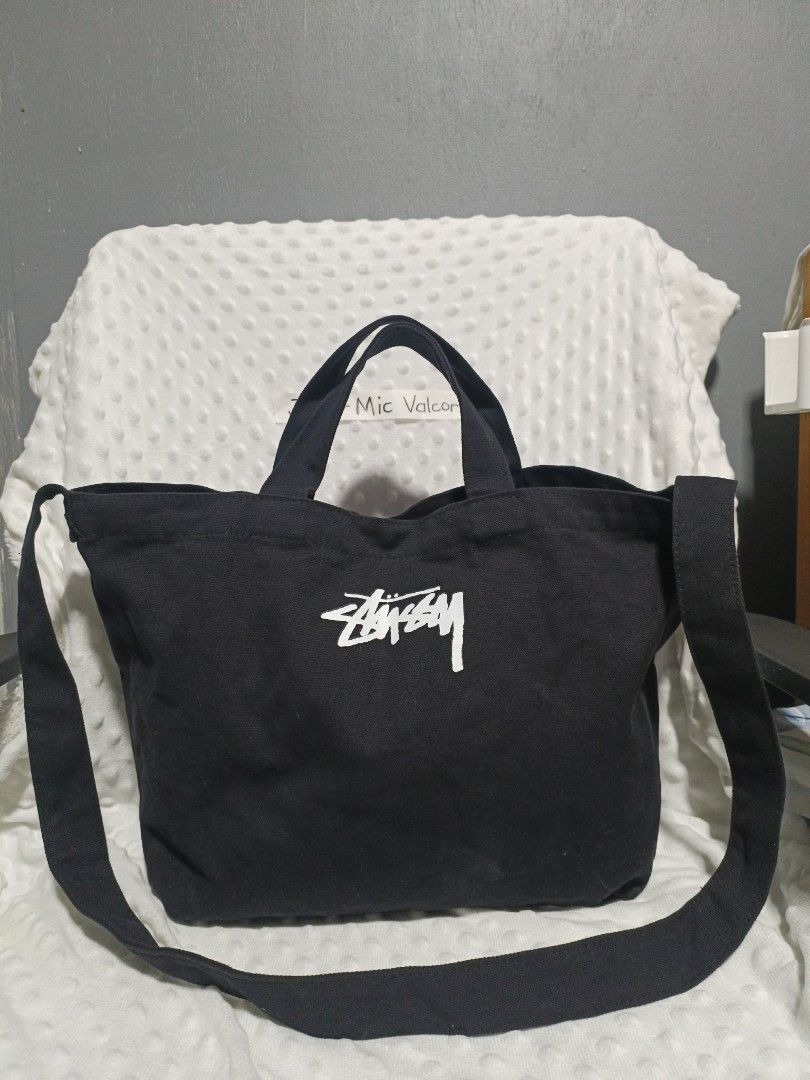 Stussy Black Canvas Tote Bag with Strap (Category: Tote Bags) located in Tanay. Submitted by micvalcorza (Listing ID 1443274995, Image 1). Description: - Brand: Stussy - Color: Black - Material: Canvas - Features: Top handles, detachable shoulder strap, printed Stussy logo on front, interior pockets - Closure: Snap button - Size: Good for everyday use.