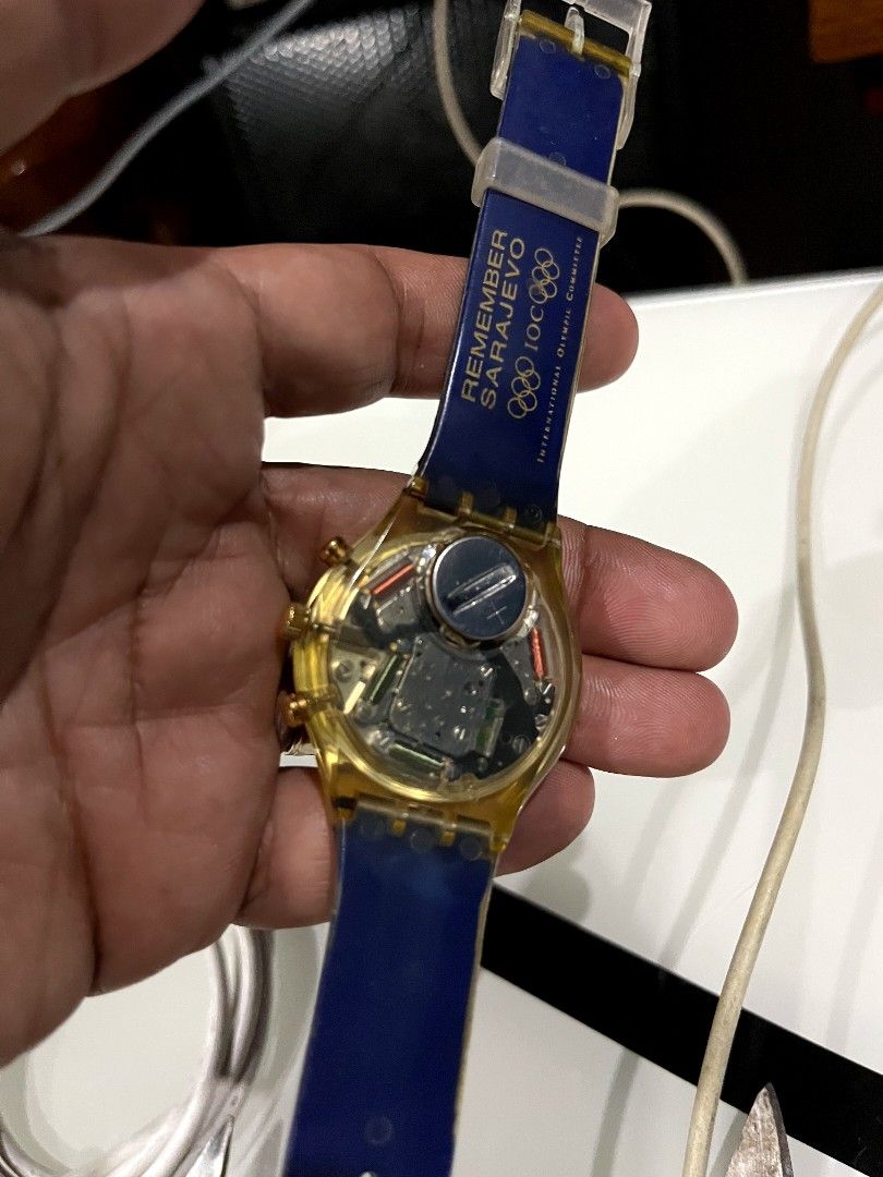 Vintage Swatch Olympic Games Chronograph Watch (Category: Men's Watches) located in Naga. Submitted by kenshin78 (Listing ID 1443246155, Image 2). Description: - Swatch Watch from the Olympic Games Collection - Year: 1994 - Dial: Blue with city names and '1994' details - Strap: Features 'Remember Sarajevo' and Olympic rings - Case: Gold-tone with chronograph pushers - Unique collector's item for sports enthusiasts.