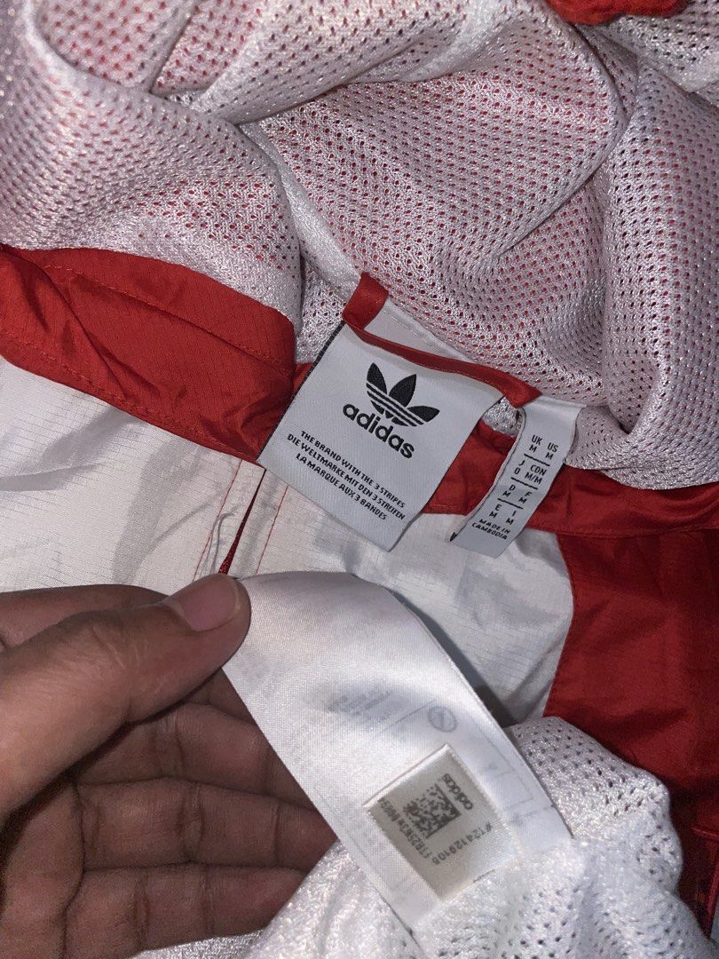 Adidas Big Trefoil Windbreaker Jacket Red White (Category: Coats, Jackets and Outerwear) located in Manila. Submitted by lianneaori10034 (Listing ID 1443327792, Image 2). Description: - Classic Adidas windbreaker in vibrant red. - Features the iconic large white Trefoil logo on the front. - White accents on sleeves and sides for a sporty look. - Hooded design for added versatility. - Adjustable drawstring hem for a customized fit. - Ideal for eve