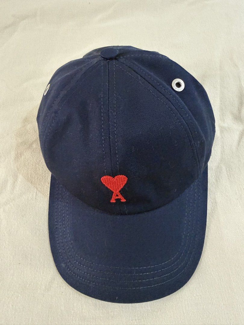 AMI Paris Ami de Coeur Cap Navy Blue (Category: Caps & Hats) located in Las Pinas. Submitted by kristinemunin (Listing ID 1443371126, Image 3). Description: - AUTHENTIC - Bought from Ssense - Like new condition/ no issue - Navy blue cap from AMI Paris - Features signature red Ami de Coeur logo embroidery - Adjustable strap at the back with AMI branded buckle - Comes with a dust bag and tags No exchange. No returns..