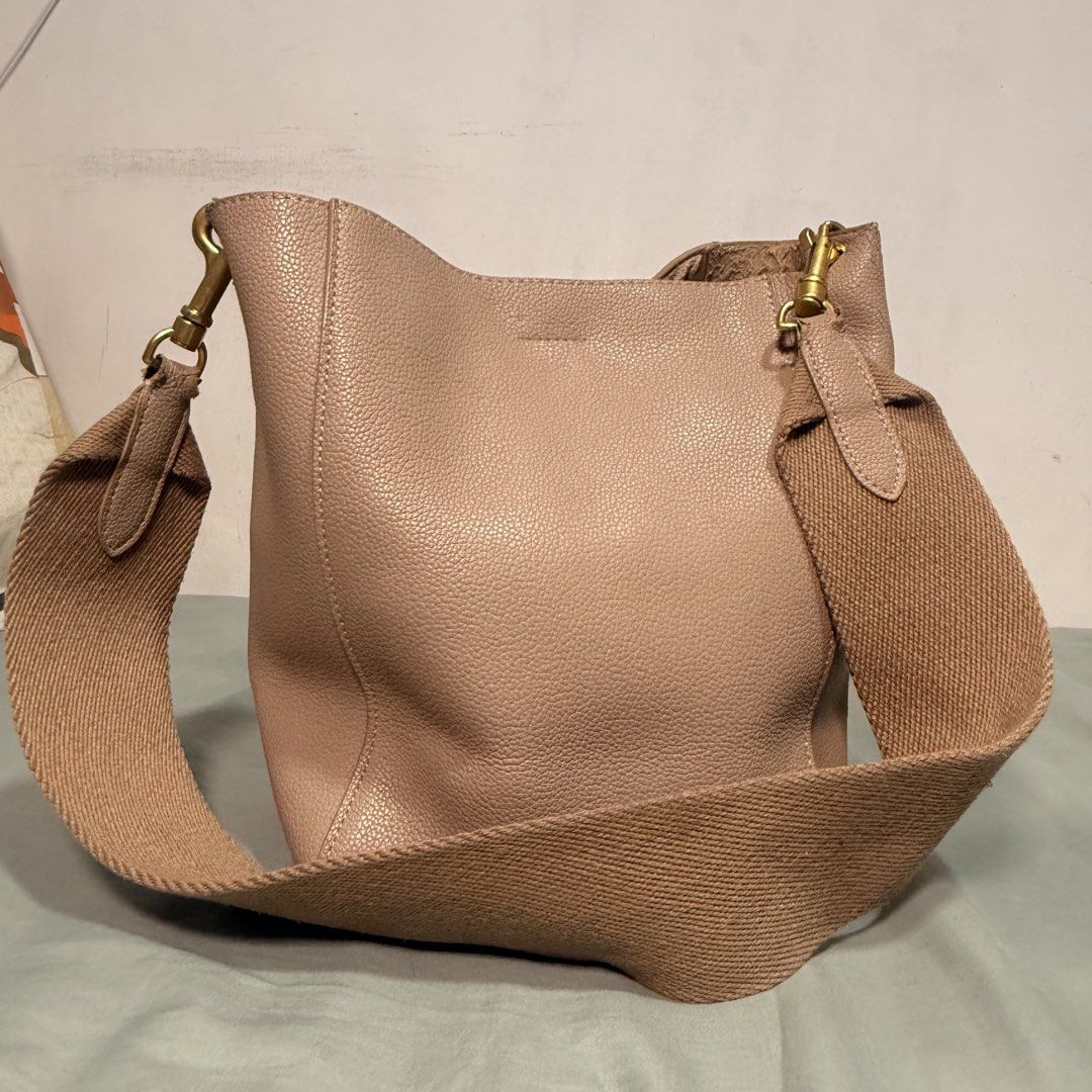 Beige Leather Bucket Bag with Wide Strap (Category: Cross-body Bags) located in Cainta. Submitted by avocado121 (Listing ID 1443457850, Image 1). Description: - Beige bucket bag - Textured leather finish - Gold-toned hardware - Wide, adjustable, and detachable strap - Interior compartments - Ideal for everyday use.
