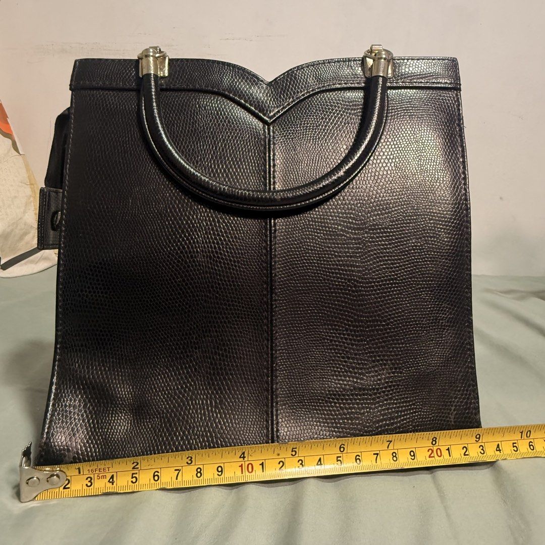 Black Textured Handbag with Top Handles (Category: Luxury Bags & Wallets) located in Cainta. Submitted by avocado121 (Listing ID 1443457863, Image 1). Description: - Stylish black handbag with a unique lizard-skin texture. - Elegant V-shaped detail on the front. - Convenient double top handles for easy carrying. - Ideal for everyday wear and versatile styling. - Compact size: approximately 10 inches wide..