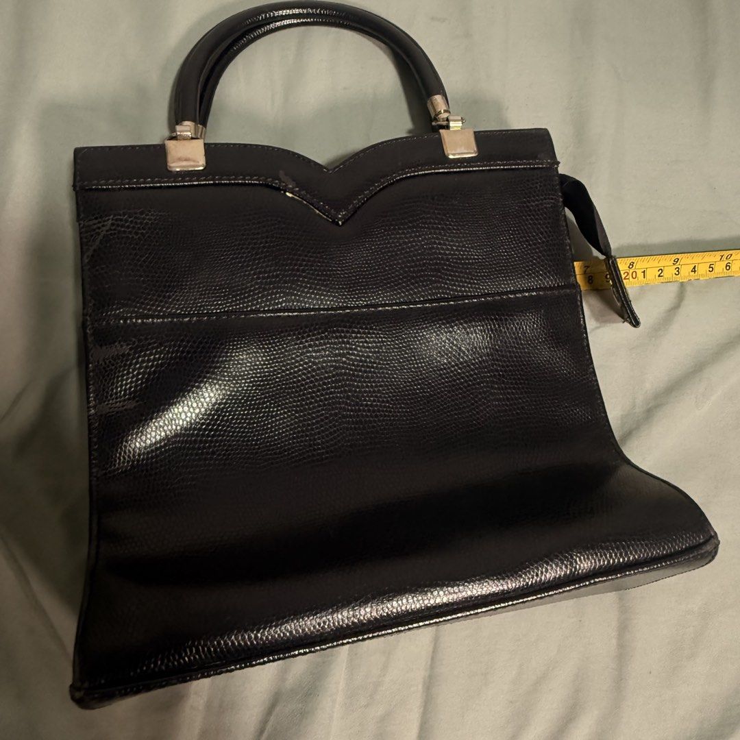 Black Textured Handbag with Top Handles (Category: Luxury Bags & Wallets) located in Cainta. Submitted by avocado121 (Listing ID 1443457863, Image 3). Description: - Stylish black handbag with a unique lizard-skin texture. - Elegant V-shaped detail on the front. - Convenient double top handles for easy carrying. - Ideal for everyday wear and versatile styling. - Compact size: approximately 10 inches wide..