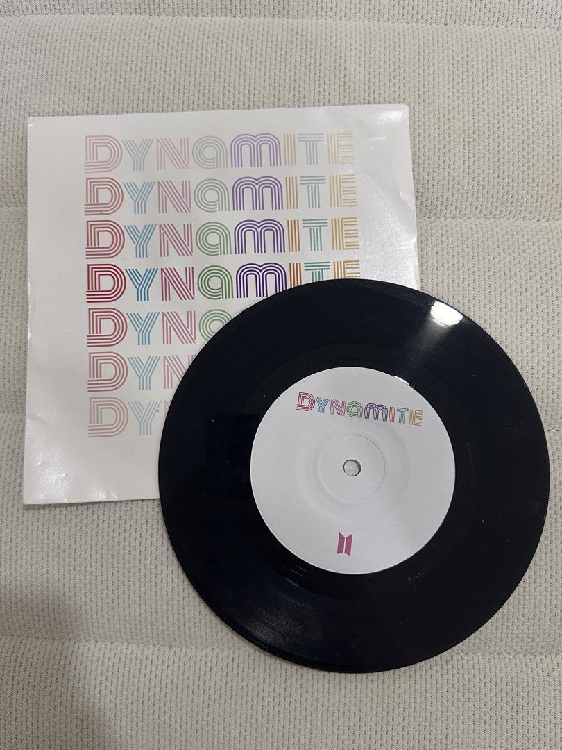 BTS Dynamite 7" Vinyl Record Single (Category: Vinyls) located in Agdangan. Submitted by mvania (Listing ID 1443429244, Image 2). Description: REASON FOR SELLING: Never got to try it. I don't have a vinyl player. Also the case has dents but the vinyl is still fine - Authentic BTS 'Dynamite' Vinyl Single - Features the hit song 'Dynamite' - Comes with original sleeve - Black vinyl with 'Dynamite' label - Sleeve design: Rainbow 'Dynamite' text and 