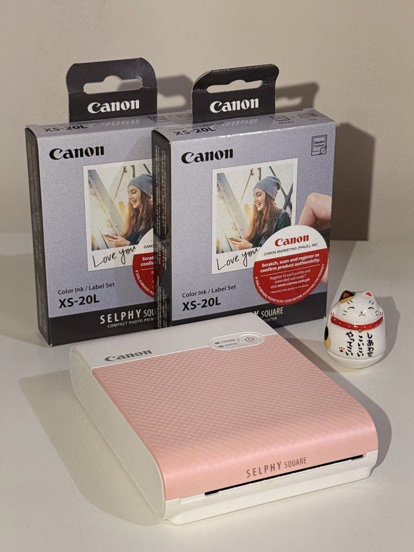 Canon Selphy Square QX10 + FREE 2 BOXES Ink Sets (Category: Printers, Scanners & Copiers) located in Quezon City. Submitted by waterwait (Listing ID 1443462163, Image 1). Description: Canon Selphy Square QX10 in pink 💗 Pre-loved, very good condition. Fully working and well-maintained. Ideal for journaling & scrapbooking. Purchased at Henry’s Cameras (online). Unit only with charging cable. FREE two (2) boxes of Canon XS-20L Color Ink/Label Sets: