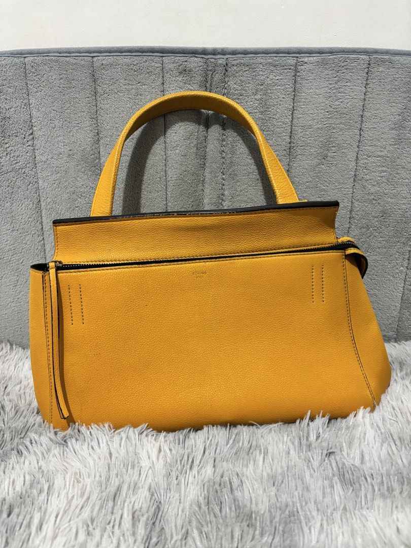 Celine Edge Yellow Leather Top Handle Bag (Category: Luxury Bags & Wallets) located in Muntinlupa City. Submitted by luxurybagprince1 (Listing ID 1443405756, Image 1). Description: - Genuine and authentic yellow Celine handbag - Made from real leather - Front pocket with snap closure - Interior zip pocket - Includes original dust bag - Versatile for everyday or special occasions - A timeless classic - With original dust bag Roughly 11” to 12” W x