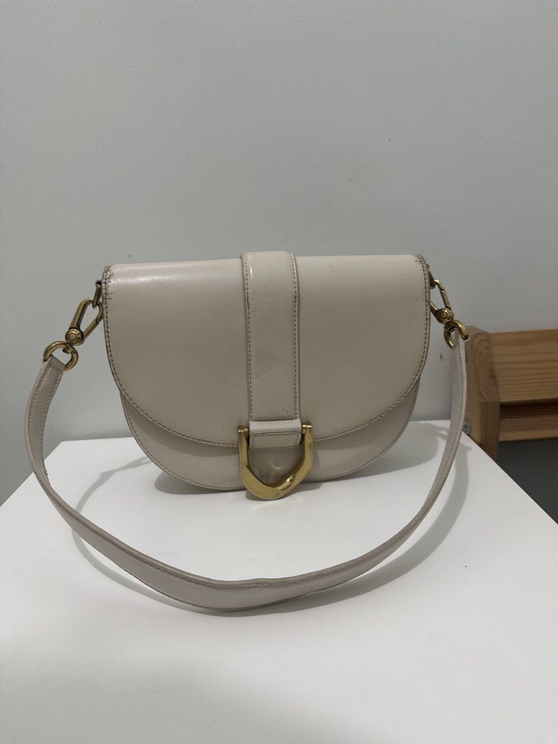 Charles & Keith Cream Shoulder Bag with Gold Hardware (Category: Shoulder Bags) located in Batangas. Submitted by z.declutter (Listing ID 1443380643, Image 2). Description: - Chic cream shoulder bag from Charles & Keith. - Features a stylish gold buckle detail on the front. - Brand name elegantly embossed on the back. - Perfect size for carrying your daily essentials. - Shows minor signs of wear on the edges, as pictured. - Selling as is..