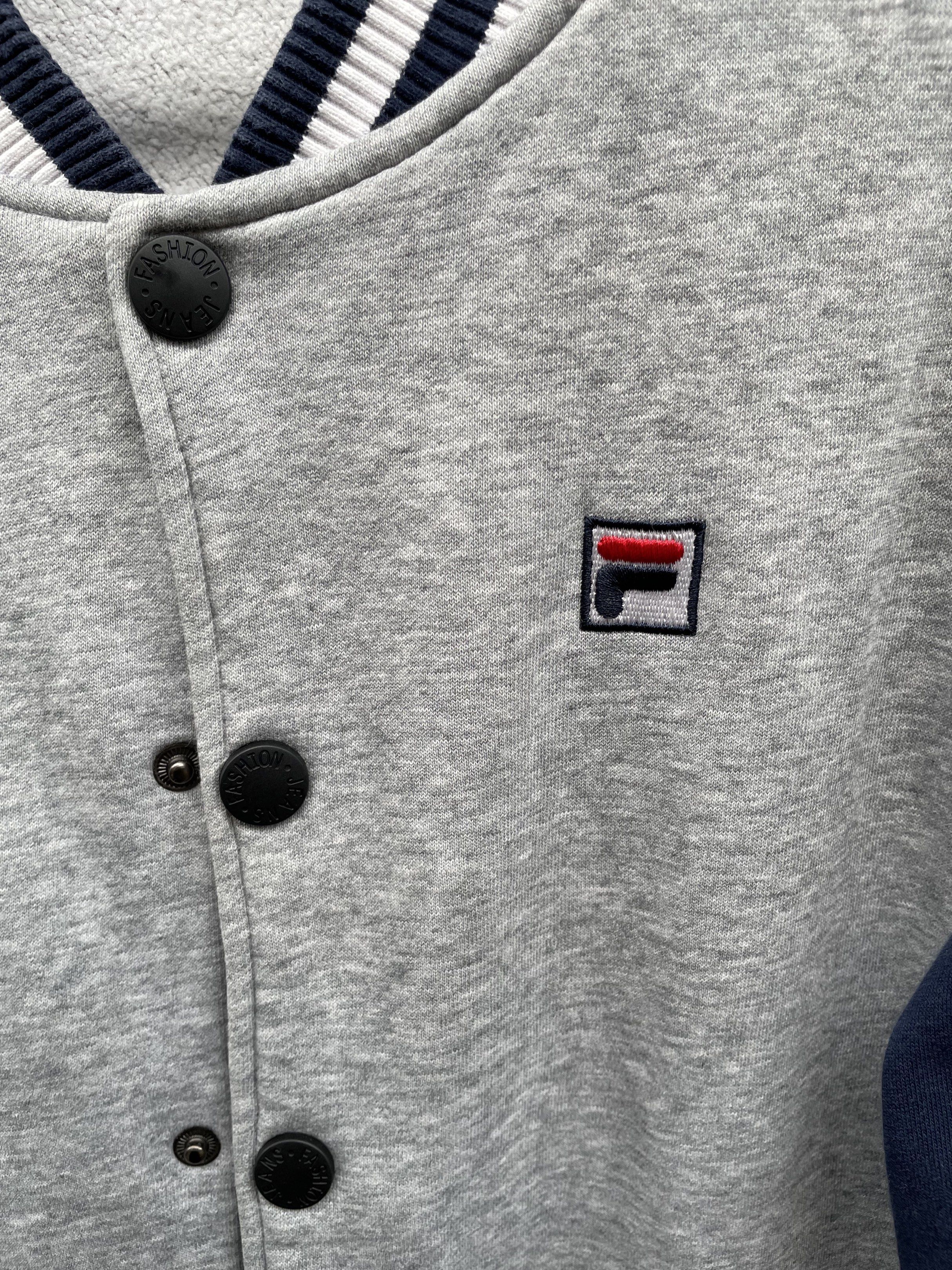 Fila Italia Heritage Varsity Jacket Grey Navy L (Category: Coats, Jackets and Outerwear) located in Calasiao. Submitted by jeekloots (Listing ID 1443324821, Image 3). Description: - Grey and navy Fila varsity jacket - Size: L - Fila logo on the front - 'Mistero Tour di Heritage' embroidery on the back - Ribbed cuffs, collar, and hem - Button-up front - Pockets.