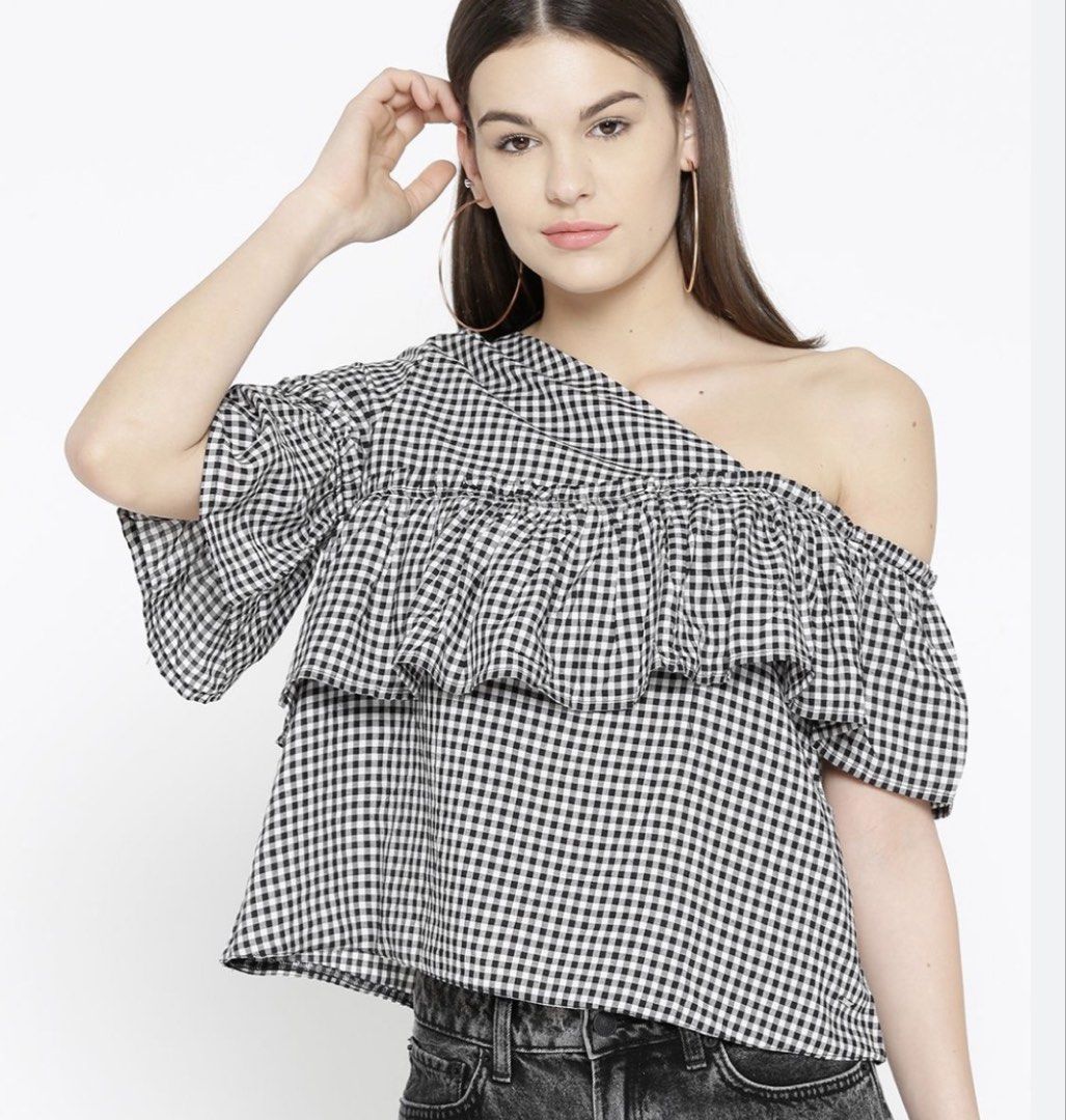 Gingham Ruffle One Shoulder Top (Category: Sleeveless) located in Taytay. Submitted by shopbye (Listing ID 1443421266, Image 2). Description: - Trendy black and white gingham pattern - Chic one-shoulder design - Adorable ruffled detail across the chest - Flared sleeves for a stylish touch - Versatile: dress it up or down for any occasion.