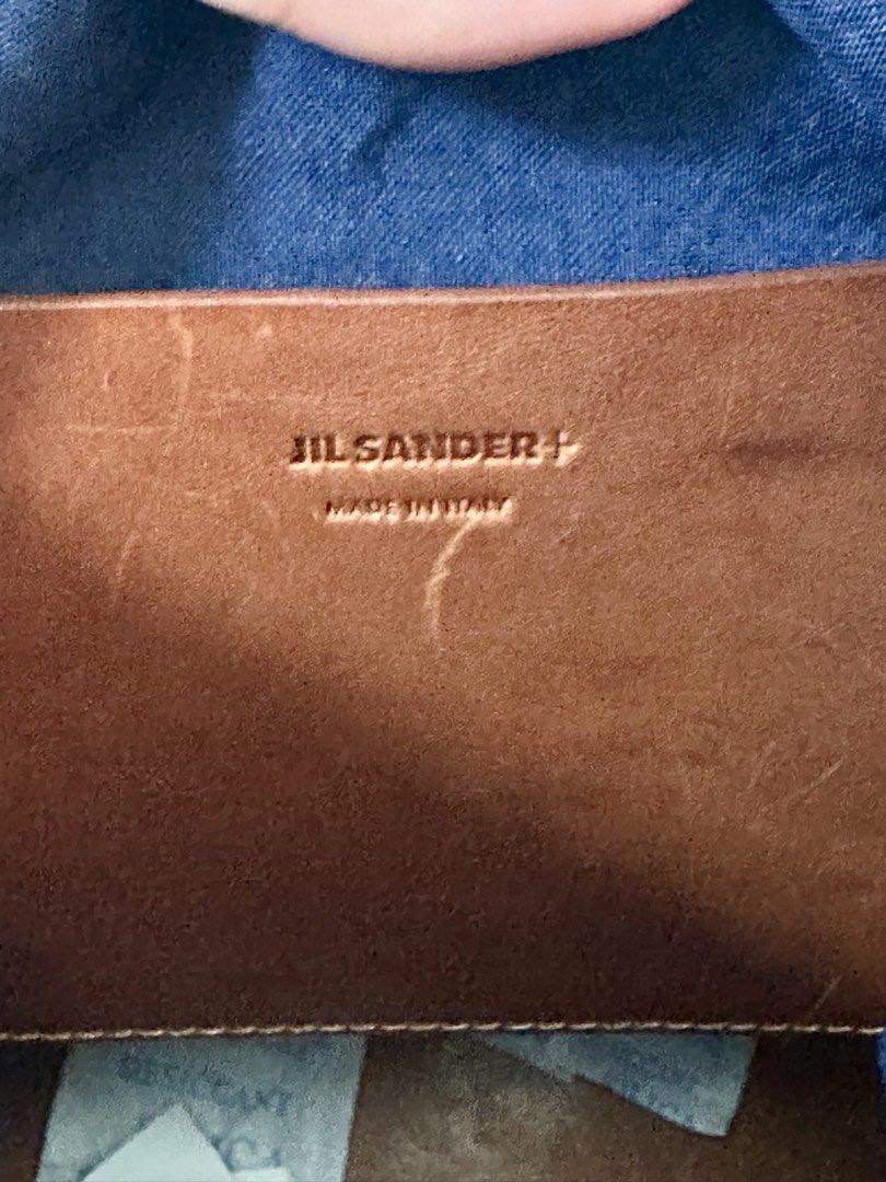 Jil Sander+ Navy Blue Canvas Leather Trim Drawstring Bag (Category: Luxury Bags & Wallets) located in Mandaluyong City. Submitted by mabv85 (Listing ID 1443370619, Image 3). Description: - Authentic Jil Sander navy blue canvas drawstring bag - Brown leather trim and pocket - Adjustable strap for crossbody or shoulder wear - Made in Italy - Includes original tag.