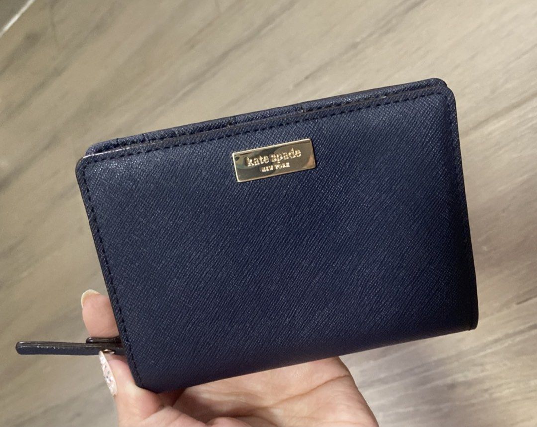 Kate Spade Navy Blue Saffiano Leather Wallet (Category: Wallets & Card holders) located in Manila. Submitted by mtomas1222 (Listing ID 1443409231, Image 1). Description: - Original Navy blue Kate Spade wallet - Genuine saffiano leather exterior - Interior features multiple card slots - Dedicated coin pouch with zipper closure - Secure snap closure for main wallet - Elegant gold hardware details -Good as new -with paper bag .