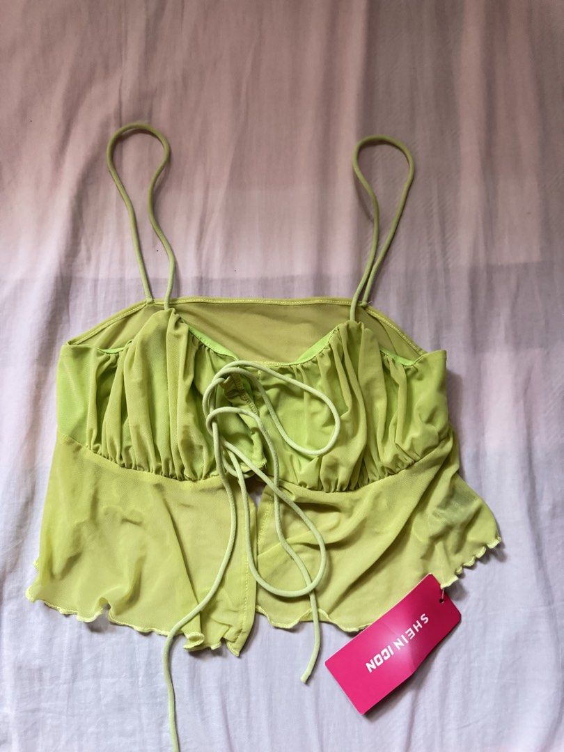 SHEIN ICON Lime Green Mesh Tie Front Crop Top (Category: Others Tops) located in Quezon City. Submitted by jamiin (Listing ID 1443414705, Image 1). Description: Can fit s-m - SHEIN ICON lime green mesh crop top - Adjustable tie front - Lettuce hem - Ruffle detail on bust - Thin spaghetti straps - Trendy for going out or festival looks - Versatile: pair with jeans or a skirt.