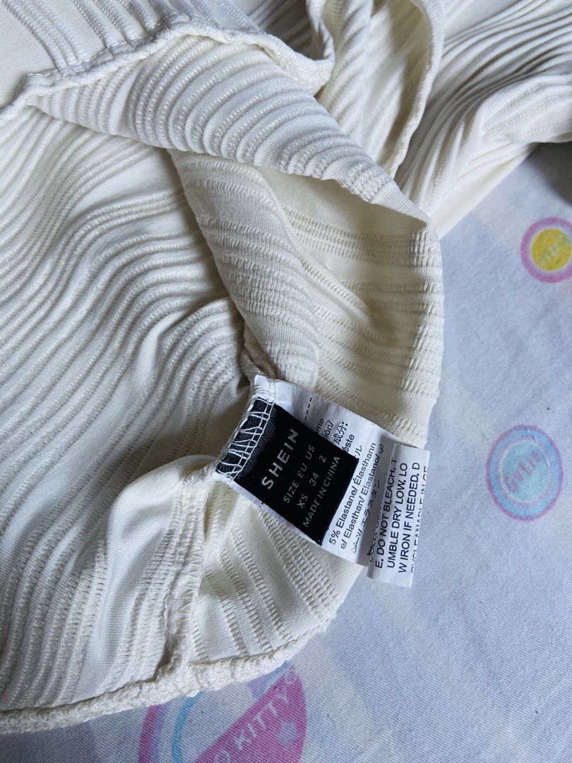 SHEIN Textured Wave Bodysuit Cream XS (Category: Blouses) located in Manila. Submitted by cherrymae_0527 (Listing ID 1443328512, Image 2). Description: - Cream textured bodysuit from SHEIN - Short sleeves - Snap closure at the bottom - Unique wavy ribbed pattern - Comfortable and stylish - Ideal for layering or wearing alone.