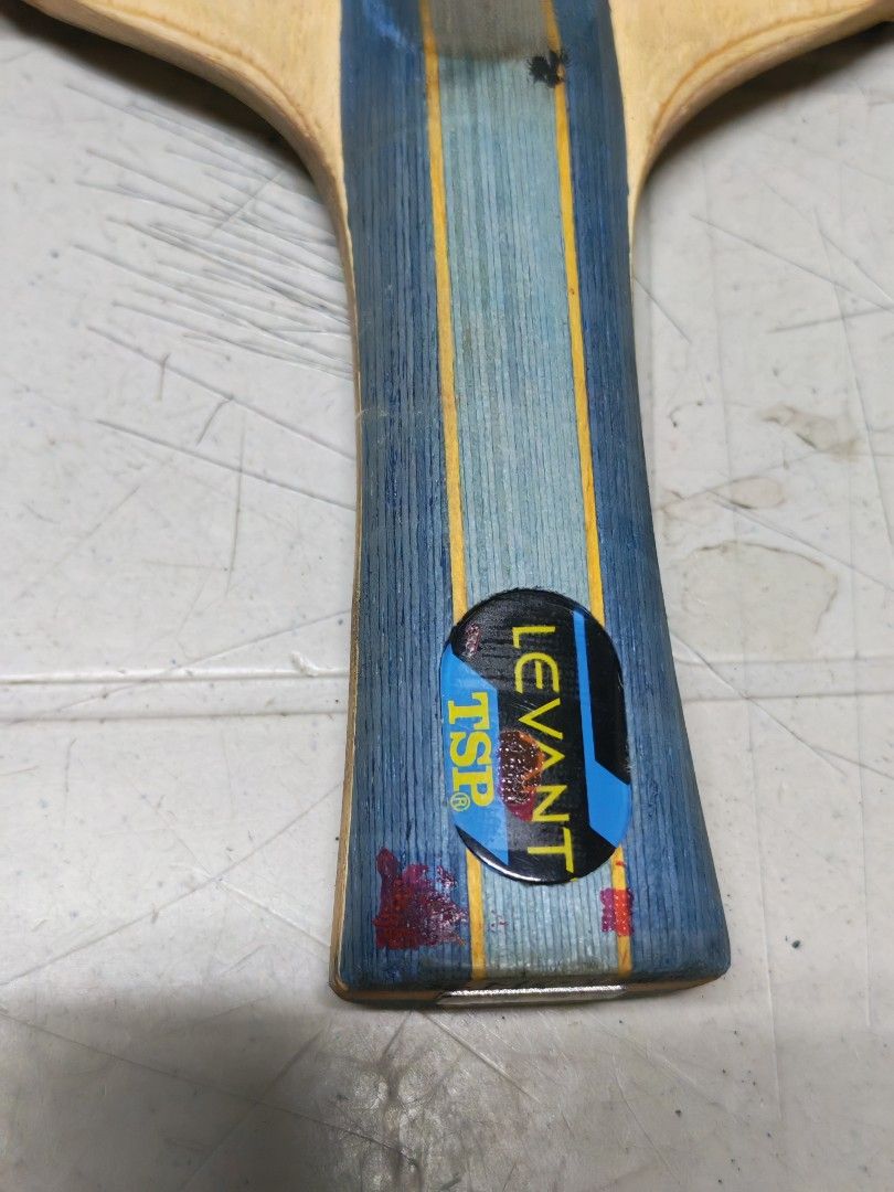TSP LEVANT Table Tennis Bat with Red Rubber (Category: Racket and Ball Sports) located in Manila. Submitted by GentleGiant (Listing ID 1443325662, Image 2). Description: - TSP LEVANT table tennis bat - Red rubber on one side - Handle features blue and yellow stripes - Minor cosmetic marks on handle and blade edge - Ideal for practice or casual play - Ready for a new owner.