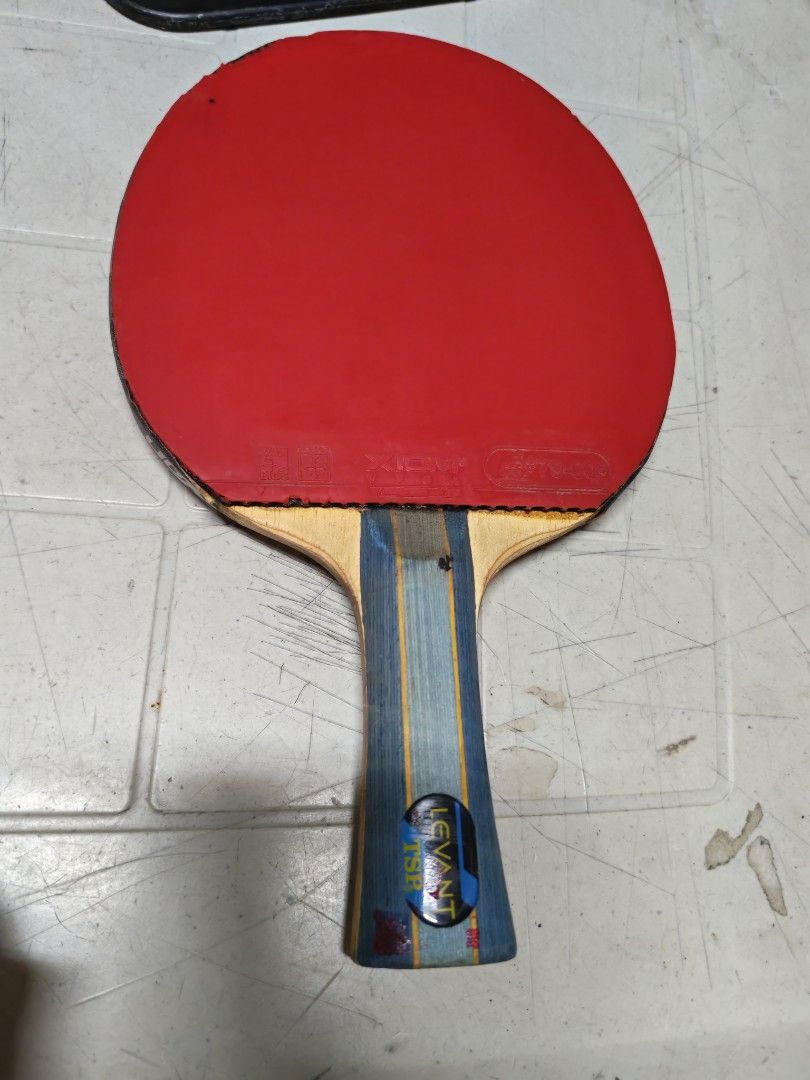 TSP LEVANT Table Tennis Bat with Red Rubber (Category: Racket and Ball Sports) located in Manila. Submitted by GentleGiant (Listing ID 1443325662, Image 1). Description: - TSP LEVANT table tennis bat - Red rubber on one side - Handle features blue and yellow stripes - Minor cosmetic marks on handle and blade edge - Ideal for practice or casual play - Ready for a new owner.