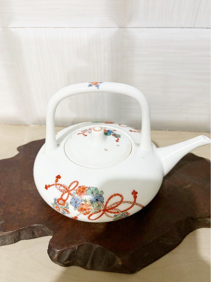 Vintage Ceramic Teapot with Floral Design (Category: Coffee & Tea Tableware) located in Bacoor. Submitted by dawnandust (Listing ID 1443334097, Image 2). Description: - White ceramic teapot - Features a lovely floral and ribbon pattern - Curved handle for easy carrying - Perfect for serving tea or as a decorative piece - Dimensions: Approx. 5 inches tall, 6 inches from spout to handle - A charming addition to any kitchen or collection.
