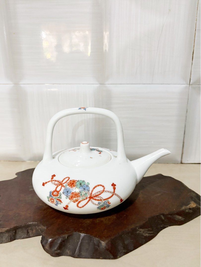 Vintage Ceramic Teapot with Floral Design (Category: Coffee & Tea Tableware) located in Bacoor. Submitted by dawnandust (Listing ID 1443334097, Image 1). Description: - White ceramic teapot - Features a lovely floral and ribbon pattern - Curved handle for easy carrying - Perfect for serving tea or as a decorative piece - Dimensions: Approx. 5 inches tall, 6 inches from spout to handle - A charming addition to any kitchen or collection.