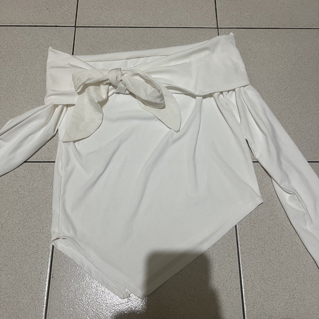 White Off-Shoulder Tie Front Long Sleeve Top (Category: Blouses) located in Manila. Submitted by twish_wish (Listing ID 1443460406, Image 1). Description: - White off-shoulder top - Long sleeves - Front tie detail - Ribbed texture - Asymmetrical hemline - Bodysuit style - Versatile for night out or casual wear.