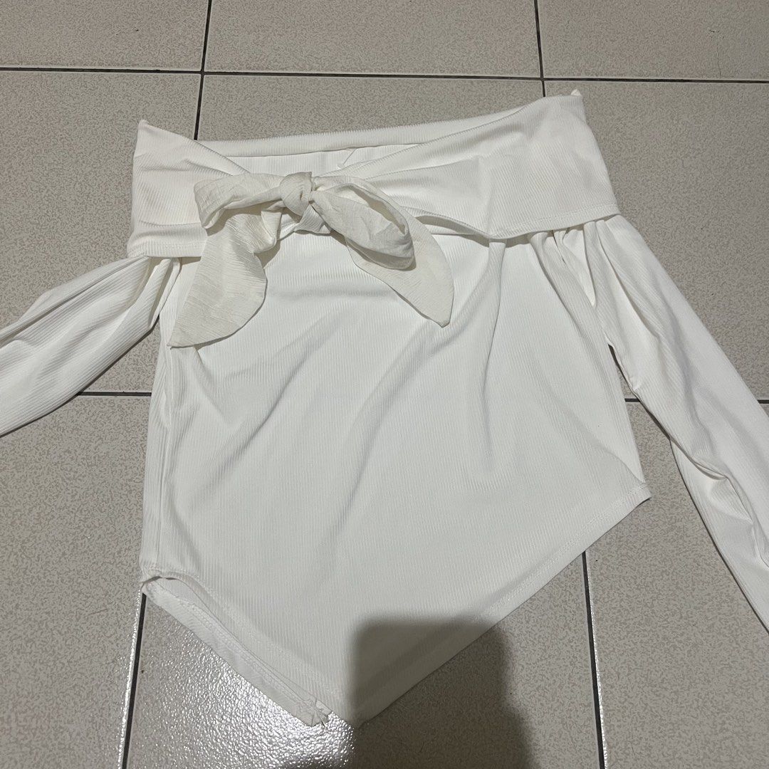 White Off-Shoulder Tie Front Long Sleeve Top (Category: Blouses) located in Manila. Submitted by twish_wish (Listing ID 1443460406, Image 2). Description: - White off-shoulder top - Long sleeves - Front tie detail - Ribbed texture - Asymmetrical hemline - Bodysuit style - Versatile for night out or casual wear.
