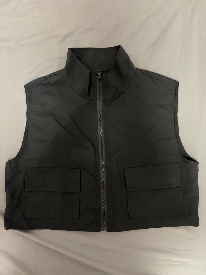 Black Cropped Utility Vest with Zip and Pockets (Category: Vests) located in Pasay City. Submitted by losient (Listing ID 1443664168, Image 1). Description: - Black cropped vest - High collar with zip closure - Two front pockets with button flaps - Sleeveless design - Ideal for layering over tops or dresses - Versatile for casual or streetwear styles.