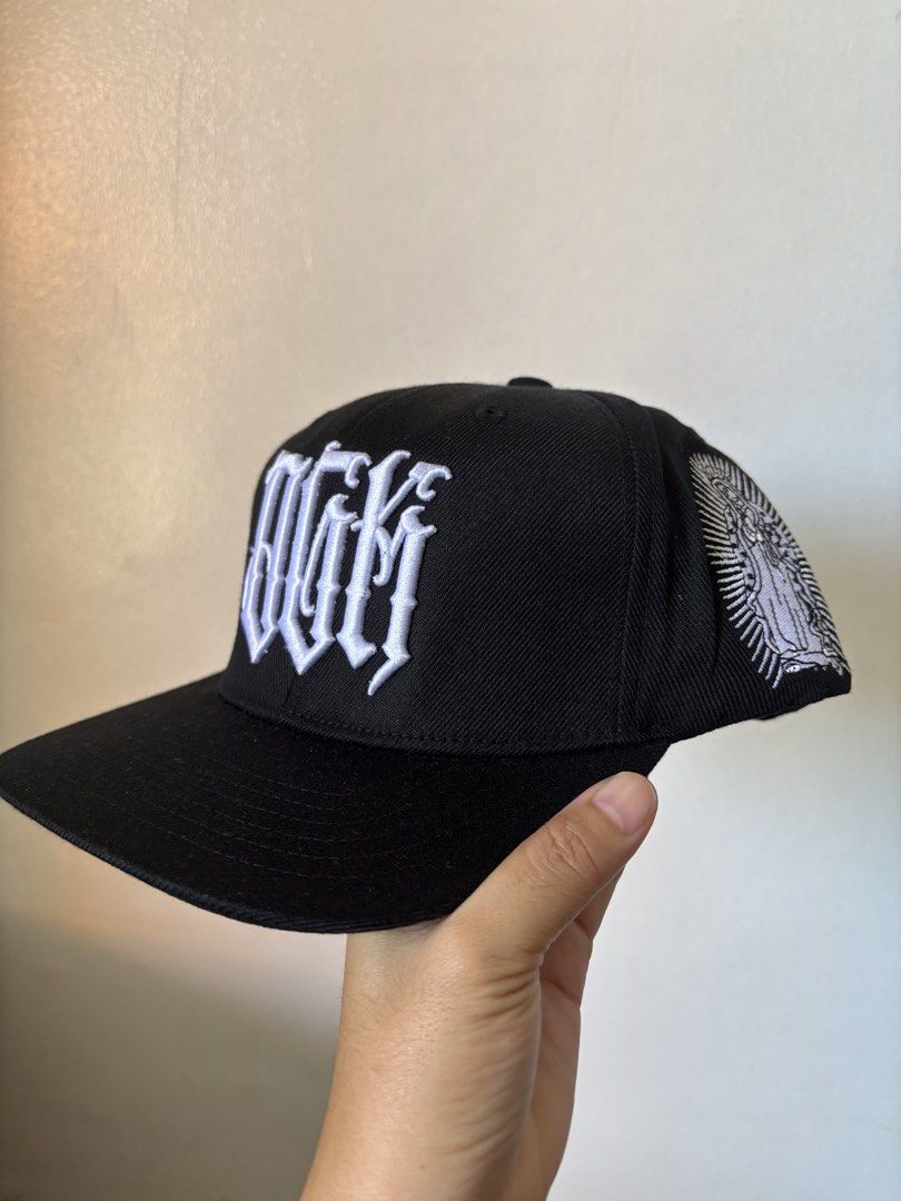 Black DGM Snapback Cap with White Embroidery (Category: Caps & Hats) located in Davao. Submitted by truepenguin_f2a806 (Listing ID 1443638856, Image 3). Description: - Black snapback cap - White DGM embroidery on the front - 'ALL DAY' embroidery on the back - Virgin Mary embroidery on the side - Brand new with tags attached - Ideal for casual wear.