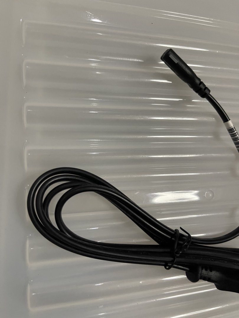 Black Power Cable with Connector (Category: Chargers & Cables) located in Quezon City. Submitted by jaedenry0228 (Listing ID 1443633683, Image 3). Description: - Black power cable - Approximately 1 meter in length - Features a standard connector on one end and a smaller connector on the other - Ideal for replacing lost or damaged power cables - Cable is neatly coiled with a barcode sticker.