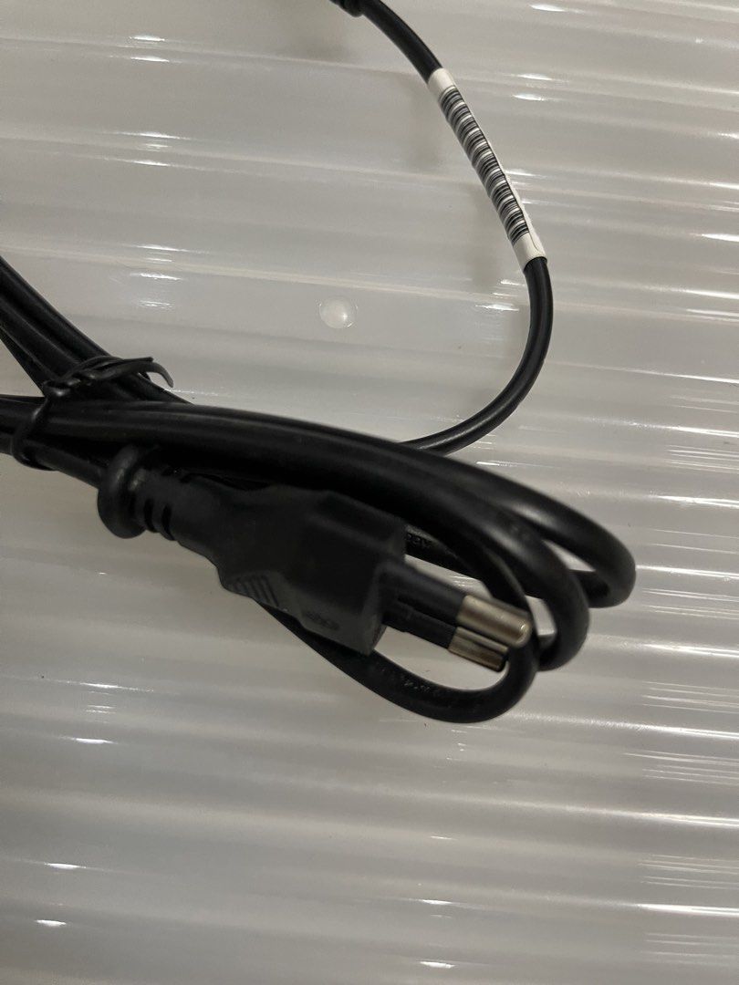 Black Power Cable with Connector (Category: Chargers & Cables) located in Quezon City. Submitted by jaedenry0228 (Listing ID 1443633683, Image 2). Description: - Black power cable - Approximately 1 meter in length - Features a standard connector on one end and a smaller connector on the other - Ideal for replacing lost or damaged power cables - Cable is neatly coiled with a barcode sticker.
