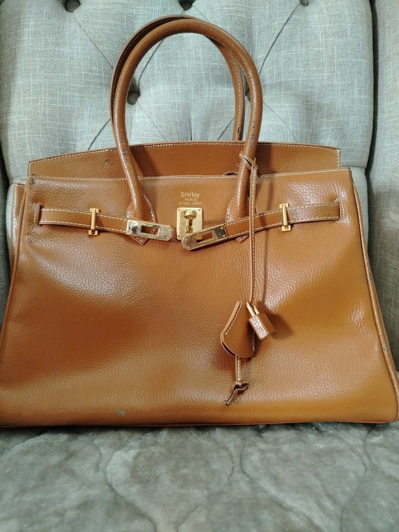Brown Leather Handbag with Gold Hardware (Category: Luxury Bags & Wallets) located in Paranaque City. Submitted by yensfashionfinds (Listing ID 1443547235, Image 1). Description: - Classic brown leather handbag - Elegant gold hardware - Secure clasp closure - Multiple interior compartments for organization - Sturdy and comfortable handles - Timeless design for any occasion - Minor signs of wear on corners and edges, hence selling at a low price.