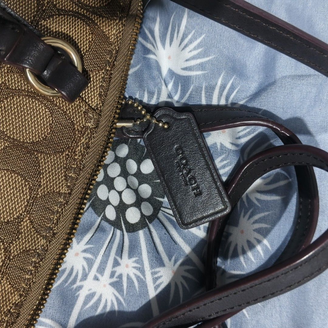 Coach Signature Monogram Canvas Satchel Bag (Category: Cross-body Bags) located in Carmona. Submitted by genkrist (Listing ID 1443553430, Image 2). Description: - Authentic brown Coach monogram canvas satchel - Features stylish leather trim and handles - Includes an adjustable crossbody strap for versatile wear - Secure zipper closure to keep your belongings safe - Interior tag confirms 'made in vietnam' - An ideal and practical bag for everyday 