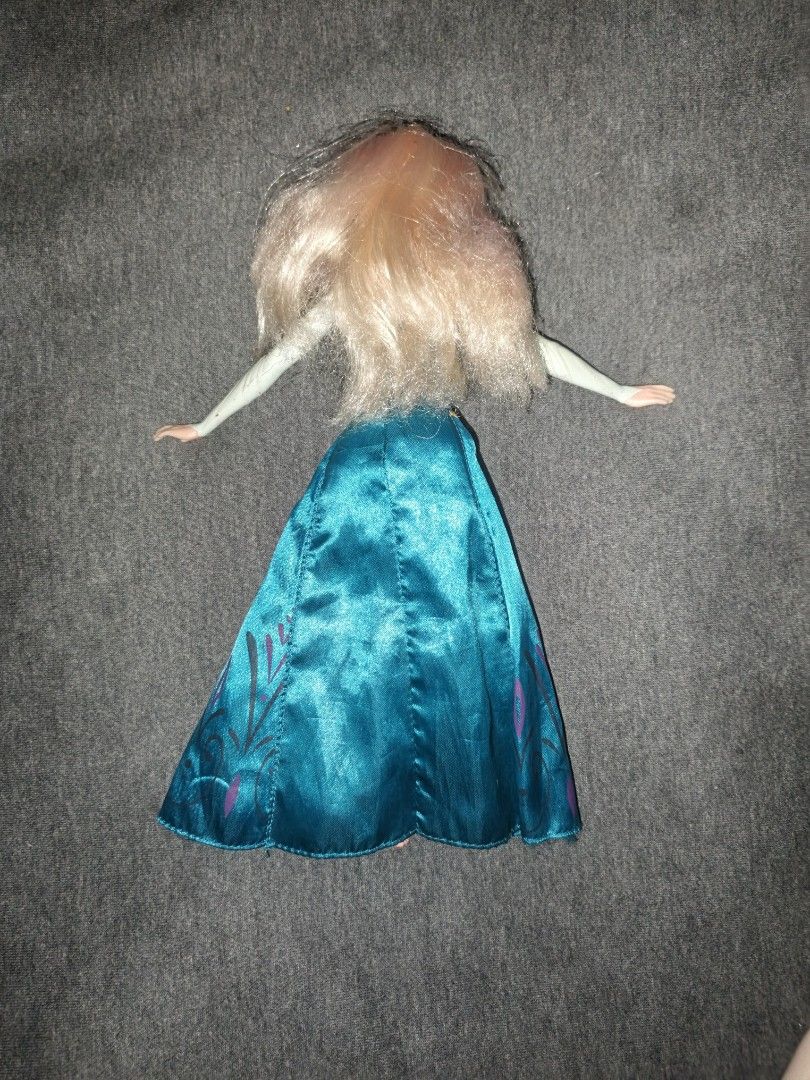 Disney Frozen Elsa Doll (Category: Figurines & Statues) located in Manila. Submitted by esteemed_shop (Listing ID 1443534078, Image 2). Description: - Elsa doll from Disney's Frozen - Iconic blue dress with purple snowflake details and a high slit - Blonde hair with subtle pink streaks - Arms are in an outstretched pose - A must-have for any Frozen enthusiast!.