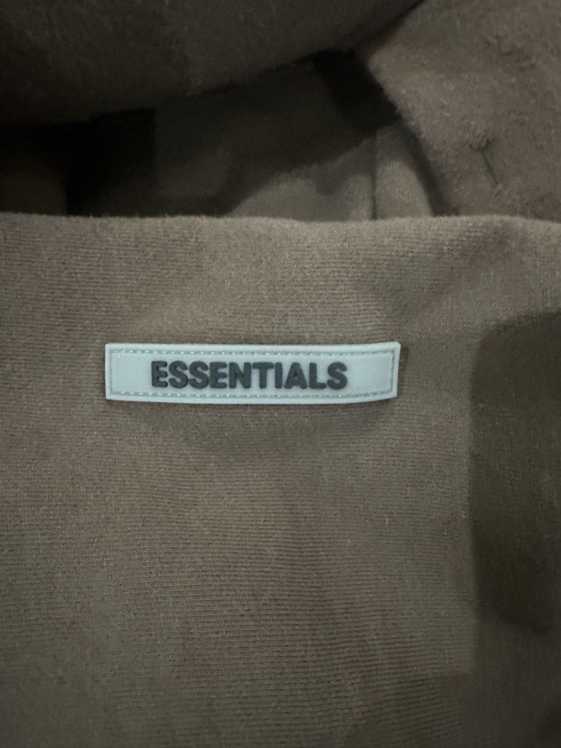 Fear of God Essentials Brown Hoodie XL (Category: Hoodies) located in Manila. Submitted by deveramaxi09722 (Listing ID 1443654747, Image 2). Description: - Brand: Fear of God Essentials - Color: Brown - Size: XL - Features: Classic Essentials logo on chest, smaller logo detail on sleeve - Origin: Made in Vietnam ISSUE IN LETTERS FALLING OFF.