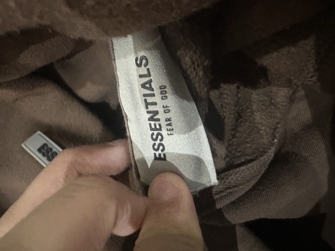 Fear of God Essentials Brown Hoodie XL (Category: Hoodies) located in Manila. Submitted by deveramaxi09722 (Listing ID 1443654747, Image 3). Description: - Brand: Fear of God Essentials - Color: Brown - Size: XL - Features: Classic Essentials logo on chest, smaller logo detail on sleeve - Origin: Made in Vietnam ISSUE IN LETTERS FALLING OFF.