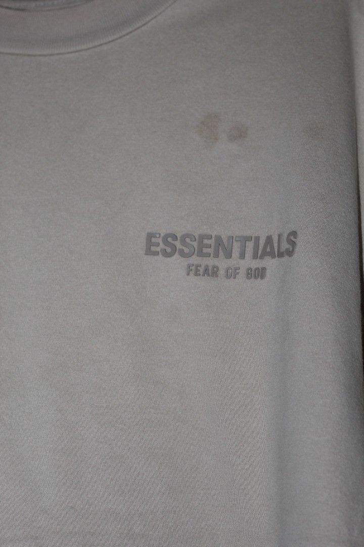 Fear of God Essentials T-shirt (Category: Tshirts & Polo Shirts ) located in Manila. Submitted by poisonthrift (Listing ID 1443656409, Image 2). Description: - Brand: Fear of God Essentials - Color: Tan - Style: Short sleeve, crew neck t-shirt - Features: Small logo detail on chest - Condition: Good, with a few faint marks on the front - Ideal for: Casual wear.