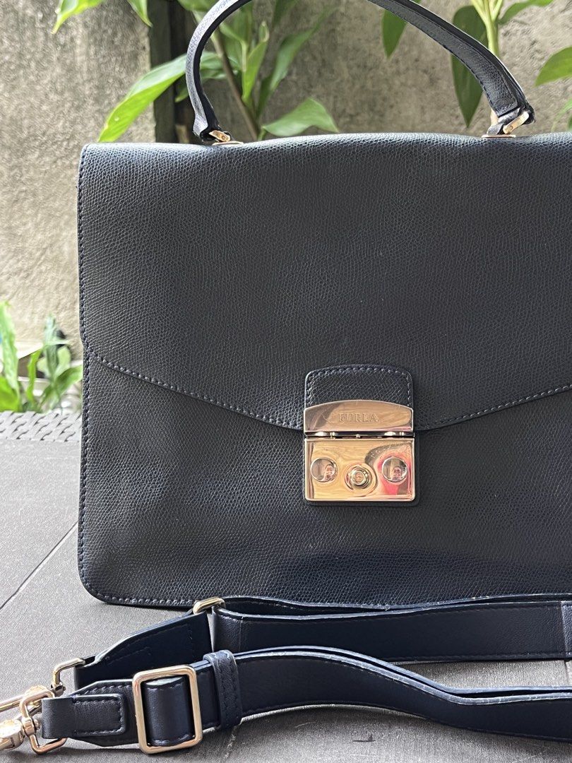 Furla Navy Leather Briefcase Bag with Shoulder Strap (Category: Luxury Bags & Wallets) located in Quezon City. Submitted by thriftfindsphqc (Listing ID 1443696651, Image 2). Description: - Navy blue leather briefcase style handbag - Secure turn-lock closure with elegant gold hardware - Includes a detachable shoulder strap for versatile carrying - Comfortable top handle - Textured leather finish for a sophisticated look - Ample interior space for 