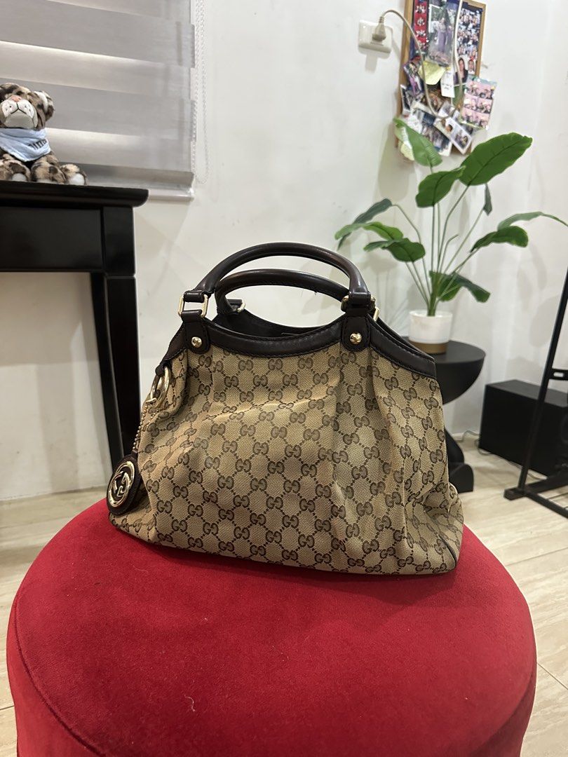 Gucci Monogram Canvas Leather Trim Handbag (Category: Luxury Bags & Wallets) located in Quezon City. Submitted by d46517 (Listing ID 1443640859, Image 1). Description: - Authentic Gucci handbag - Classic GG monogram canvas - Dark brown leather trim and handles - Magnetic snap closure - Spacious interior with light-colored lining - Minor signs of wear on interior lining - Great everyday bag.