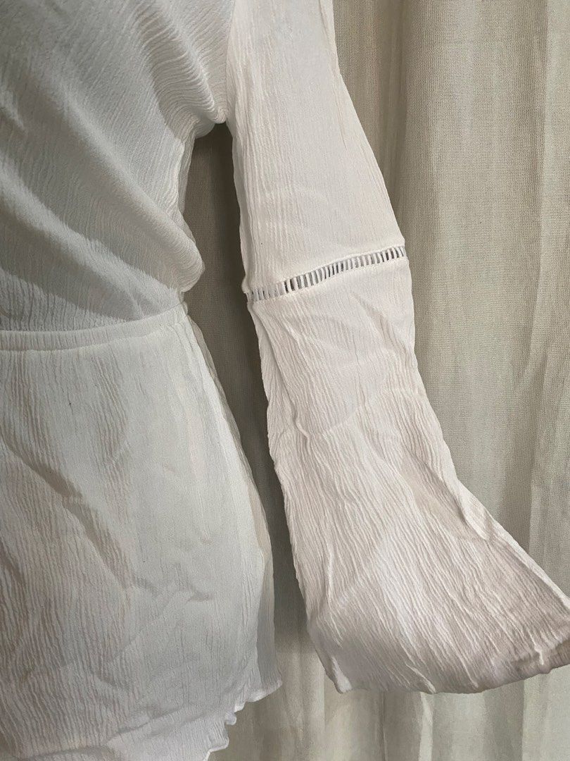 H&M White Textured V-Neck Tie Front Romper (Category: Rompers) located in Manila. Submitted by cami0110 (Listing ID 1443656447, Image 3). Description: - White textured romper from H&M - V-neck with a tie front detail - Long bell sleeves with stylish cut-out details - Comfortable elasticated waist - Ideal for beach days or casual outings -Visible stains at the back.