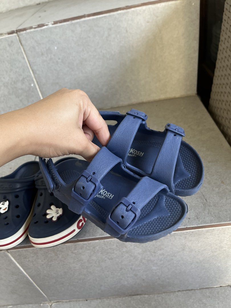 Kids' Crocs & OshKosh Sandals Bundle - Navy Blue (Category: Babies & Kids Fashion) located in Antipolo. Submitted by pixieglowphl (Listing ID 1443672721, Image 3). Description: - Bundle includes 2 pairs of kids' shoes. - Pair 1: Navy blue Crocs with fun Mickey Mouse Jibbitz. - Pair 2: Navy blue OshKosh sandals with secure buckle closures. - Both pairs are in good, pre-loved condition. - Ideal for summer adventures and everyday play. - Ready for a