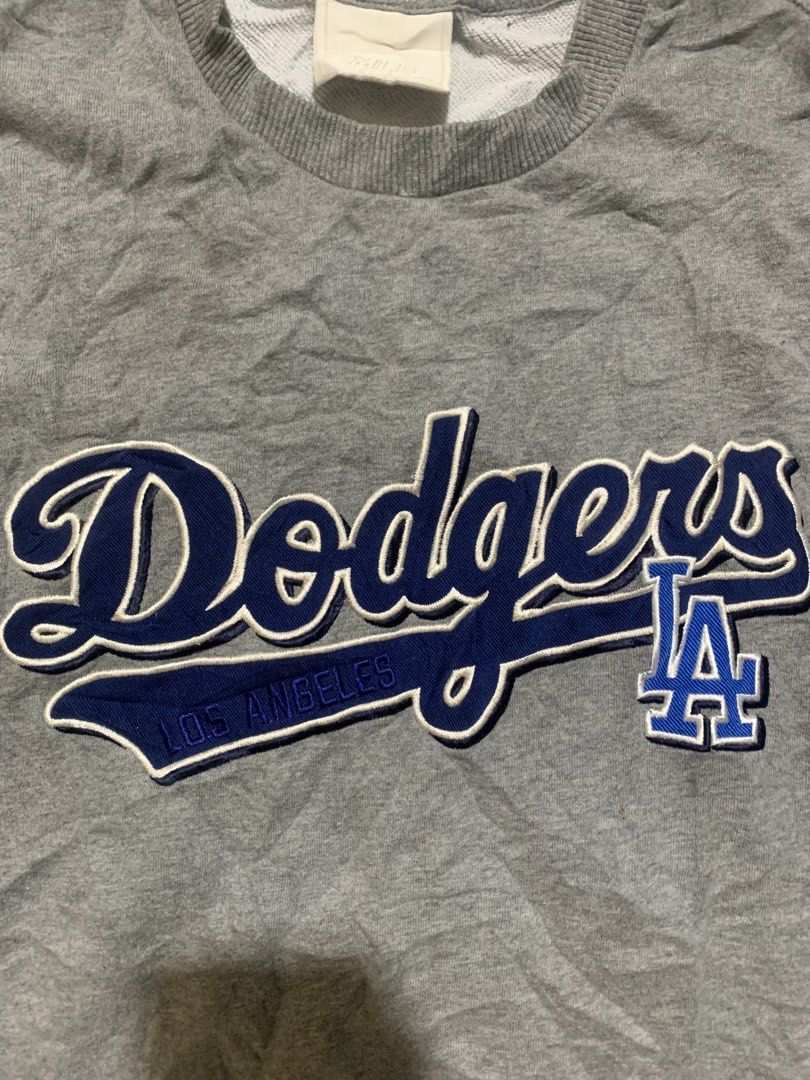 LA Dodgers MLB Grey Crewneck Sweatshirt (Category: Coats, Jackets and Outerwear) located in Iloilo. Submitted by johnpullan30303 (Listing ID 1443679179, Image 2). Description: - Grey LA Dodgers MLB crewneck sweatshirt - Iconic embroidered Dodgers logo on the chest - LA Dodgers team patch on the left sleeve - Comfortable crewneck design - MLB official tag visible inside - Perfect for Los Angeles Dodgers fans.