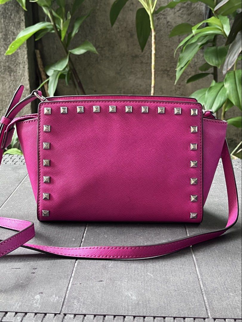 Michael Kors Pink Studded Crossbody Bag (Category: Cross-body Bags) located in Quezon City. Submitted by thriftfindsphqc (Listing ID 1443696409, Image 2). Description: - Authentic Pink Michael Kors Crossbody Bag - Stylish silver stud details on front and sides - Adjustable strap for comfortable wear - Secure zipper closure - Minor orange mark on bottom corner (visible in last photo).