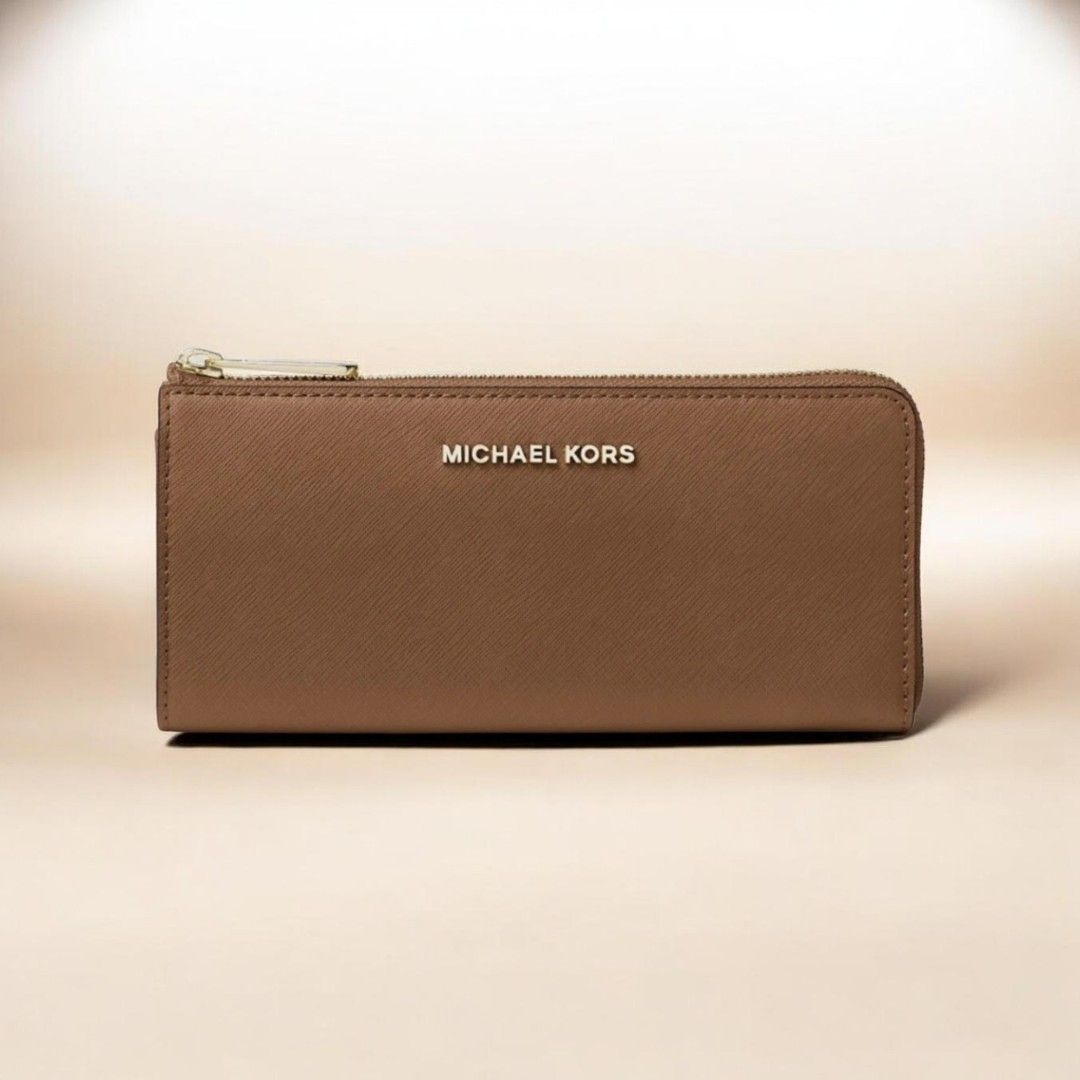 Michael Kors Saffiano Leather Zip Around Wallet (Category: Wallets & Card holders) located in Baguio. Submitted by msgold2601 (Listing ID 1443553661, Image 1). Description: - Authentic Michael Kors wallet - Rich brown Saffiano leather - Elegant gold-tone hardware - Secure zip-around closure - Interior: 1 center zip pocket, 8 card slots - Dimensions: 8"W x 4"H x 0.5"D - Handle drop: 6.25" - Adjustable strap: 18.75"-22.5" - Durable 100% polyester l