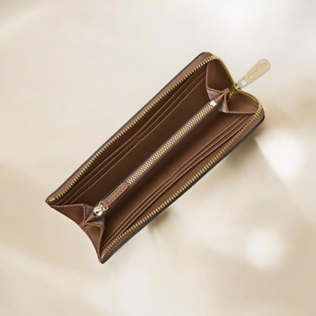 Michael Kors Saffiano Leather Zip Around Wallet (Category: Wallets & Card holders) located in Baguio. Submitted by msgold2601 (Listing ID 1443553661, Image 2). Description: - Authentic Michael Kors wallet - Rich brown Saffiano leather - Elegant gold-tone hardware - Secure zip-around closure - Interior: 1 center zip pocket, 8 card slots - Dimensions: 8"W x 4"H x 0.5"D - Handle drop: 6.25" - Adjustable strap: 18.75"-22.5" - Durable 100% polyester l