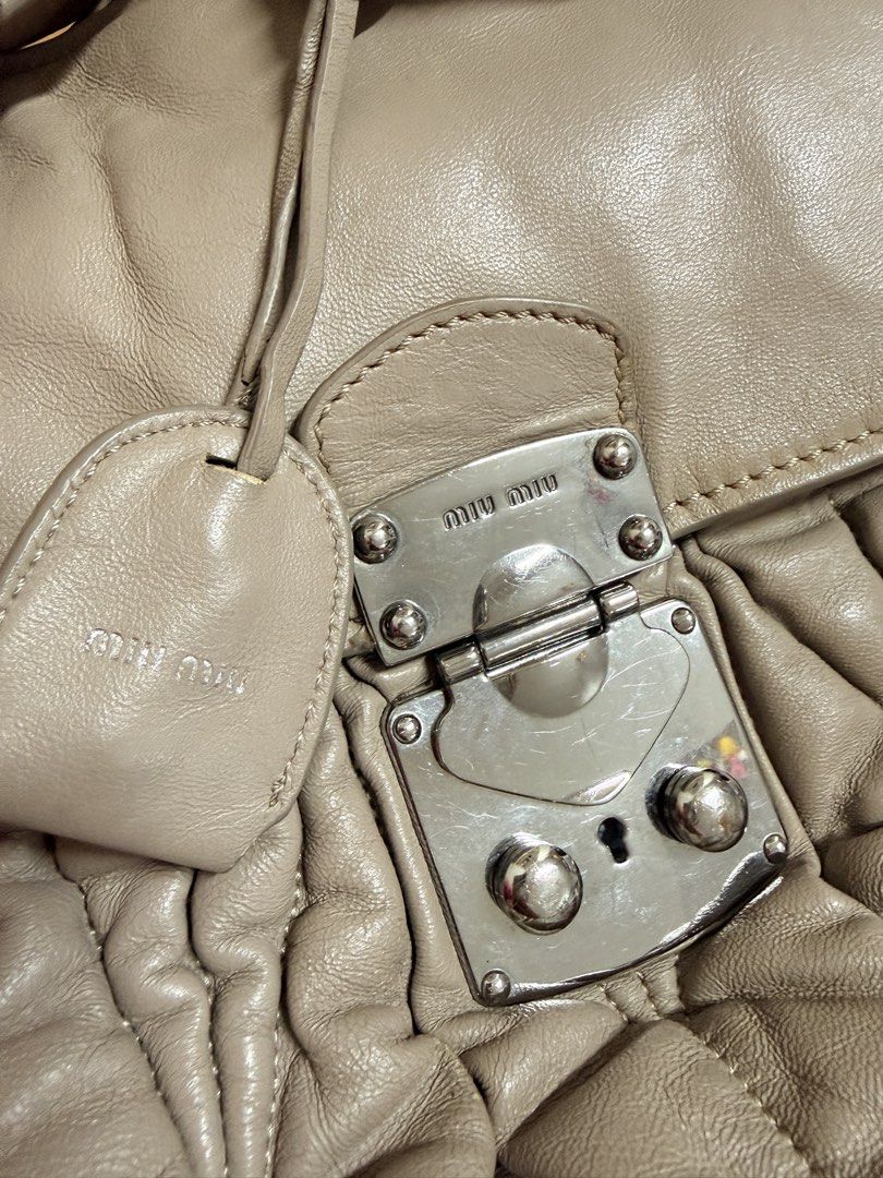 Miu Miu Ruched Leather Shoulder Bag (Category: Luxury Bags & Wallets) located in Pasig City. Submitted by rachereal11 (Listing ID 1443546483, Image 3). Description: - Taupe Miu Miu shoulder bag - Soft, ruched leather exterior - Silver turn-lock closure - Chain and leather strap - Purple satin interior lining - Interior zip pocket - Minor signs of wear on hardware and leather - Ideal for everyday use -Please self authenticate as I have no means to