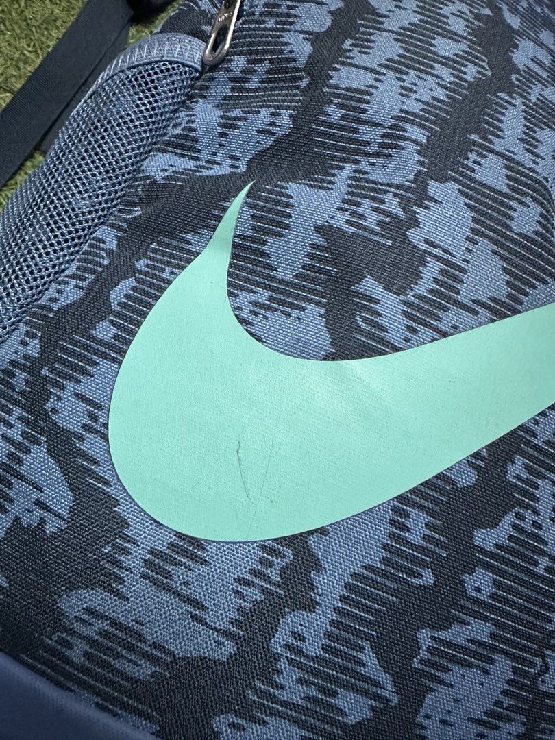 Nike Brasilia (2pcs bundle) (Category: Backpacks) located in Manila. Submitted by fadsntrendsetc (Listing ID 1443555751, Image 2). Description: - 2 bags for only 2000 - Stylish blue and black camouflage Nike backpack - Features a vibrant mint green Nike swoosh - Convenient mesh side pockets for water bottles or essentials - Bottom shows slight signs of wear, - Ideal for school, gym, or everyday adventures .