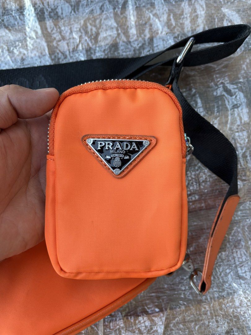 Prada Orange Nylon Triangle Bag with Pouch (Category: Luxury Bags & Wallets) located in Calabanga. Submitted by jijithriftcamarinessur (Listing ID 1443605998, Image 3). Description: - Authentic Orange Prada Nylon Bag Set - Includes main triangle pouch and smaller detachable pouch - Adjustable black strap - Zipper closure on both pouches - Ideal for carrying essentials - Please check photos for detailed condition.