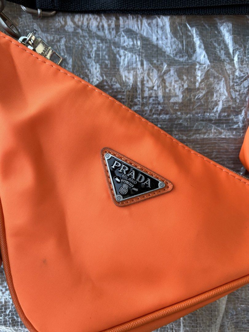 Prada Orange Nylon Triangle Bag with Pouch (Category: Luxury Bags & Wallets) located in Calabanga. Submitted by jijithriftcamarinessur (Listing ID 1443605998, Image 2). Description: - Authentic Orange Prada Nylon Bag Set - Includes main triangle pouch and smaller detachable pouch - Adjustable black strap - Zipper closure on both pouches - Ideal for carrying essentials - Please check photos for detailed condition.