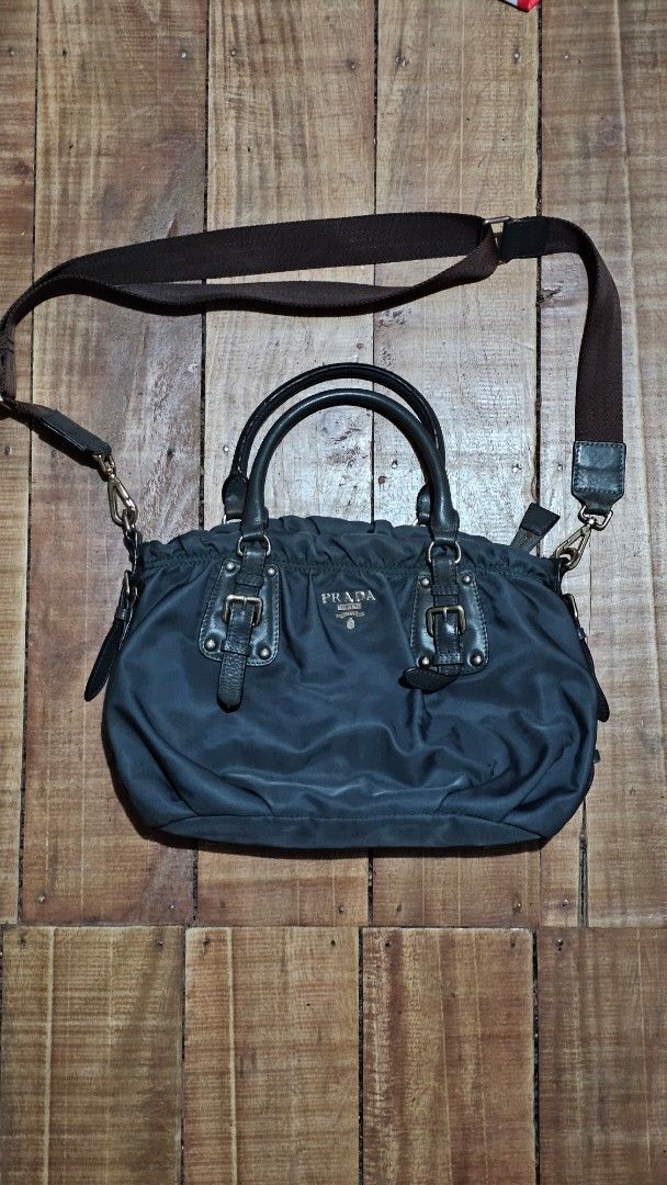 Prada Tessuto Nylon Handbag with Leather Trim (Category: Luxury Bags & Wallets) located in Kibawe. Submitted by Thrift_ni_Babac (Listing ID 1443613832, Image 1). Description: - Prada bag - Color: Black nylon with leather accents - Hardware: Gold - Features: Top handles and detachable shoulder strap - Zipper: Works smoothly - Style: Classic Prada piece See last two photo for issue and Sign of usage.