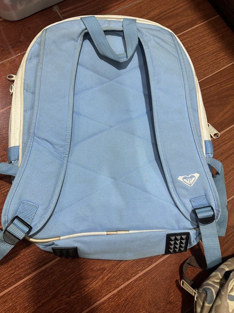 Roxy New Zealand Light Blue Backpack (Category: Backpacks) located in Paranaque City. Submitted by thriftclothing101 (Listing ID 1443601456, Image 3). Description: - Light blue Roxy backpack - Features 'New Zealand' graphic - Front pocket with Roxy logo - Main compartment with multiple sections - Adjustable straps - Minor marks on the front pocket - Ideal for school or everyday use.