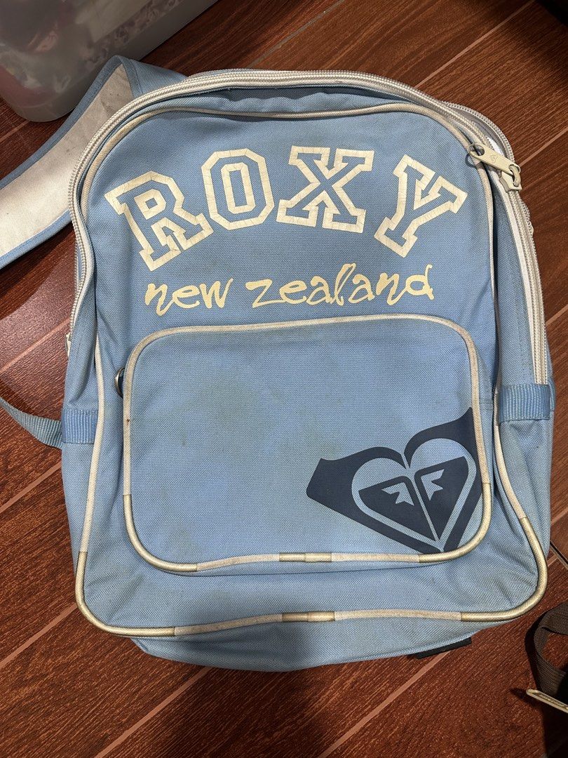 Roxy New Zealand Light Blue Backpack (Category: Backpacks) located in Paranaque City. Submitted by thriftclothing101 (Listing ID 1443601456, Image 1). Description: - Light blue Roxy backpack - Features 'New Zealand' graphic - Front pocket with Roxy logo - Main compartment with multiple sections - Adjustable straps - Minor marks on the front pocket - Ideal for school or everyday use.
